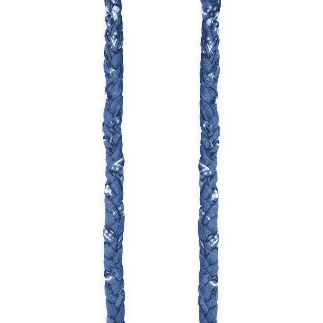 Cordon tressé bleu en tissu avec des motifs délicats. La texture du tissu est bien visible, mettant en avant un design élégant et contemporain.