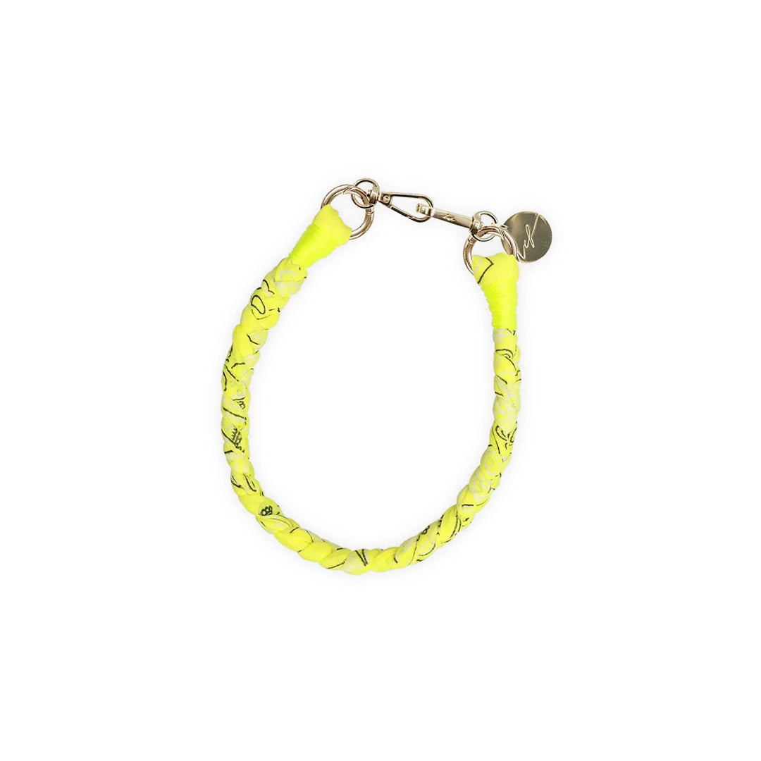 Un collier tressé en tissu bandana jaune fluo, équipé de mousquetons dorés et d'une médaille gravée "LCF". Un accessoire vibrant et élégant pour compléter vos tenues.