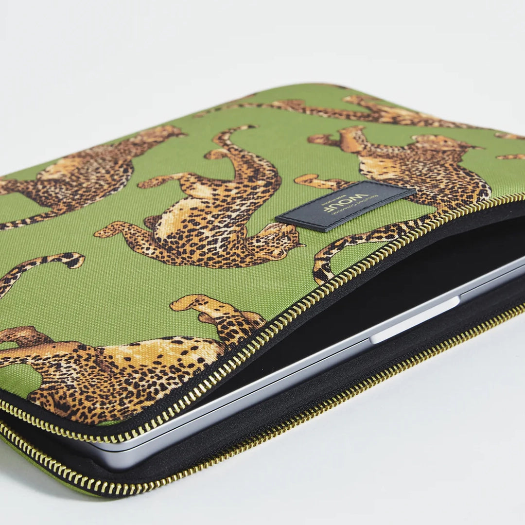 Gros plan de la housse d'ordinateur Olive Leopard de Wouf montrant une fermeture éclair dorée et des motifs de léopards sur un fond vert olive