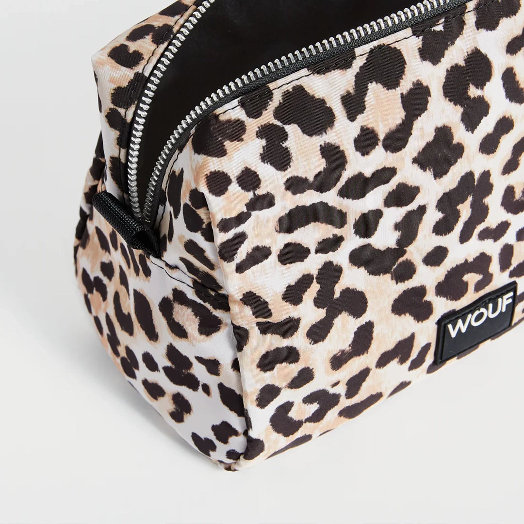 Gros plan sur la fermeture éclair de la trousse de toilette Kim par Wouf, montrant le motif léopard et la tirette en cuir recyclé.