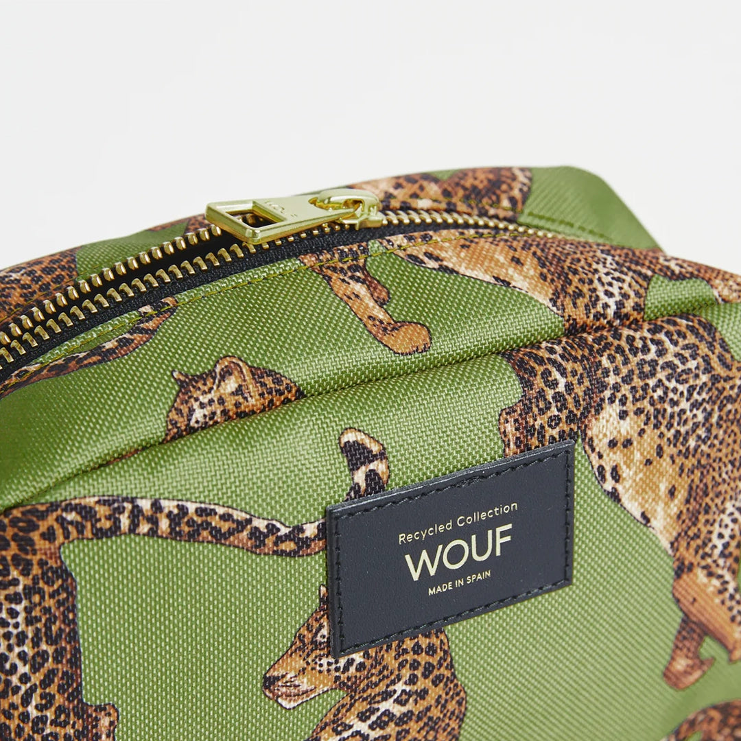Gros plan sur la trousse de toilette Olive Leopard de Wouf, montrant sa fermeture éclair dorée et son étiquette en cuir recyclé