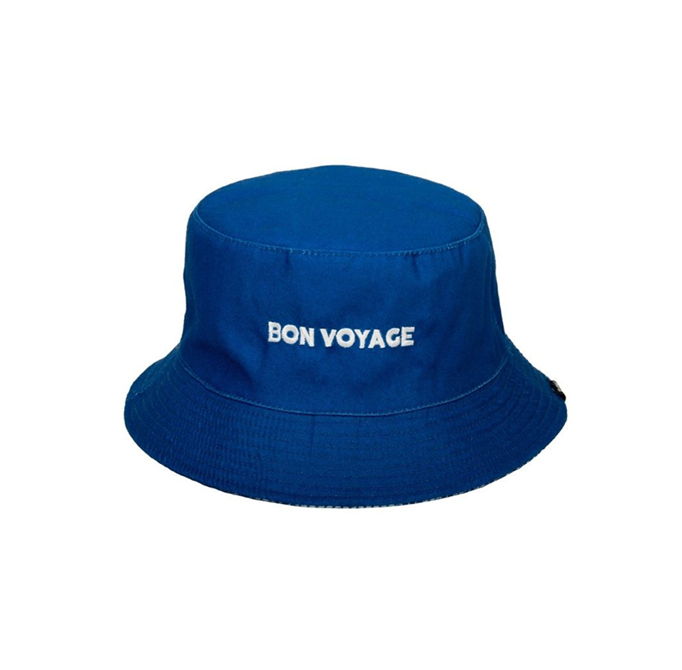 Bob bleu foncé réversible, avec une face unie et une autre à motifs imprimés accompagnés du texte « bon voyage ».