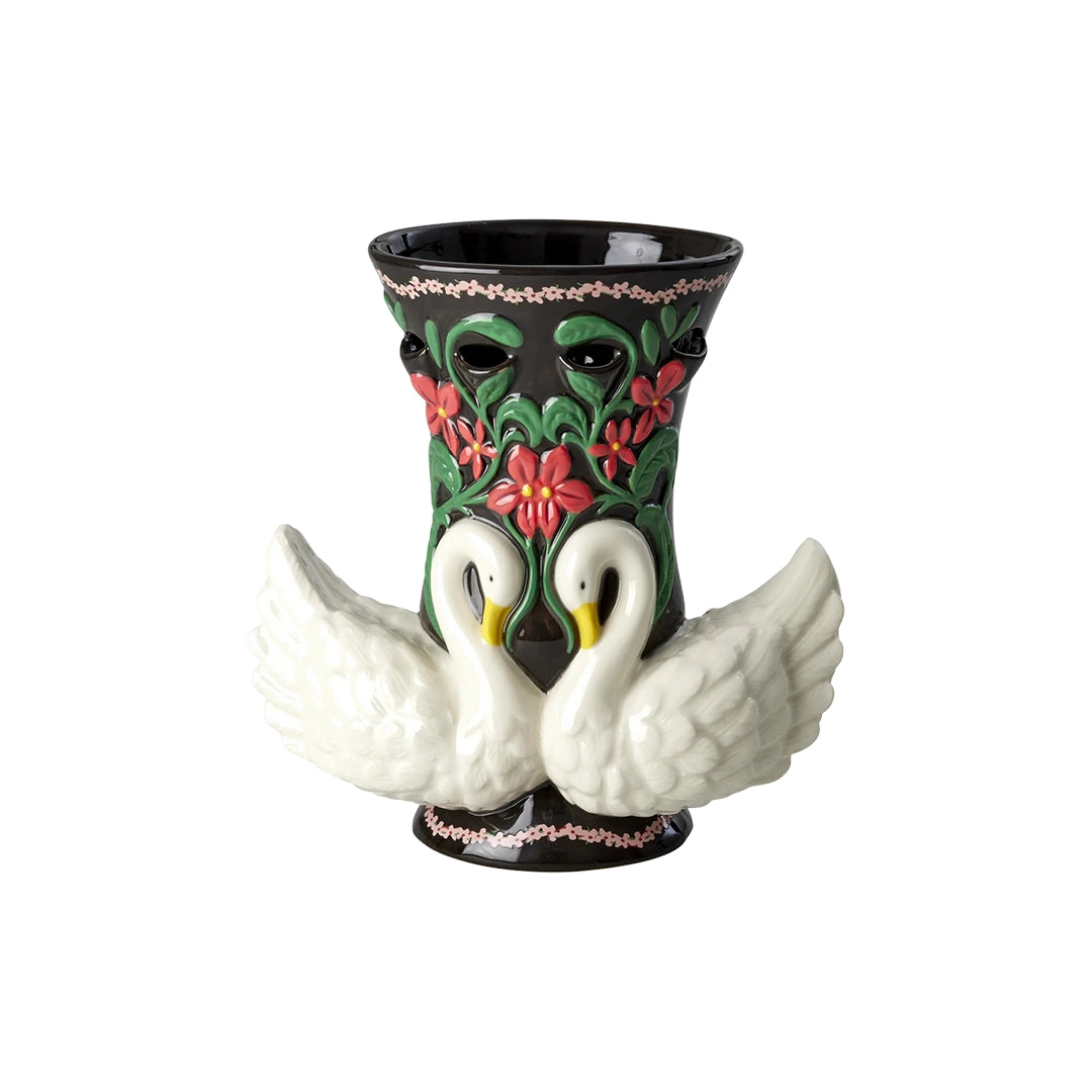 Vase en céramique noir en forme de cygnes entrelacés, avec des motifs floraux rouges et verts.