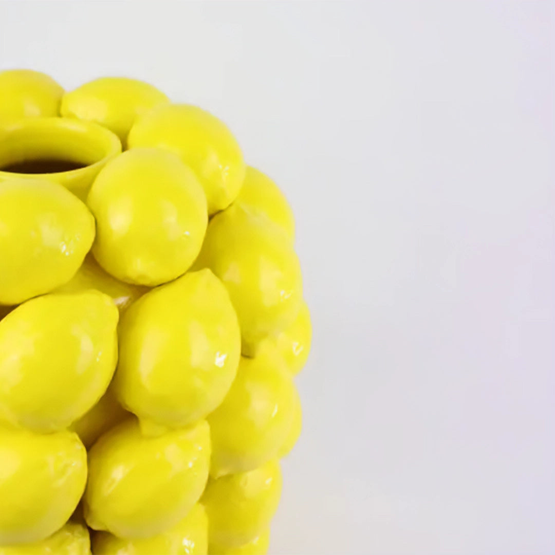 Gros plan sur le Vase Limone en céramique jaune avec un motif citron en relief. Une pièce idéale pour ajouter une touche d'originalité et de fraîcheur à votre intérieur.